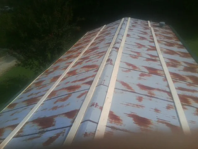 Rusted metal roof panels with new wood purlins before replacement — Storm Damage Roof Repair in Jewell by Roofing Brothers